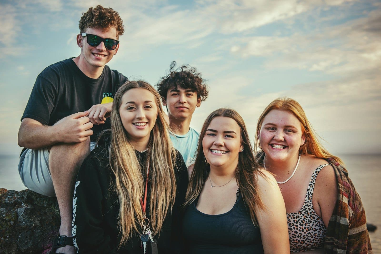 A group of teenagers smiling together outdoors