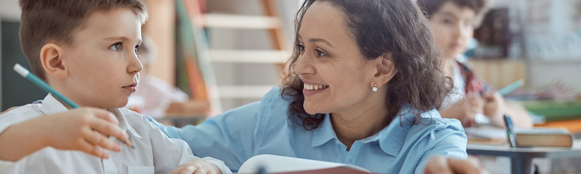 A teacher listening to a young student in class