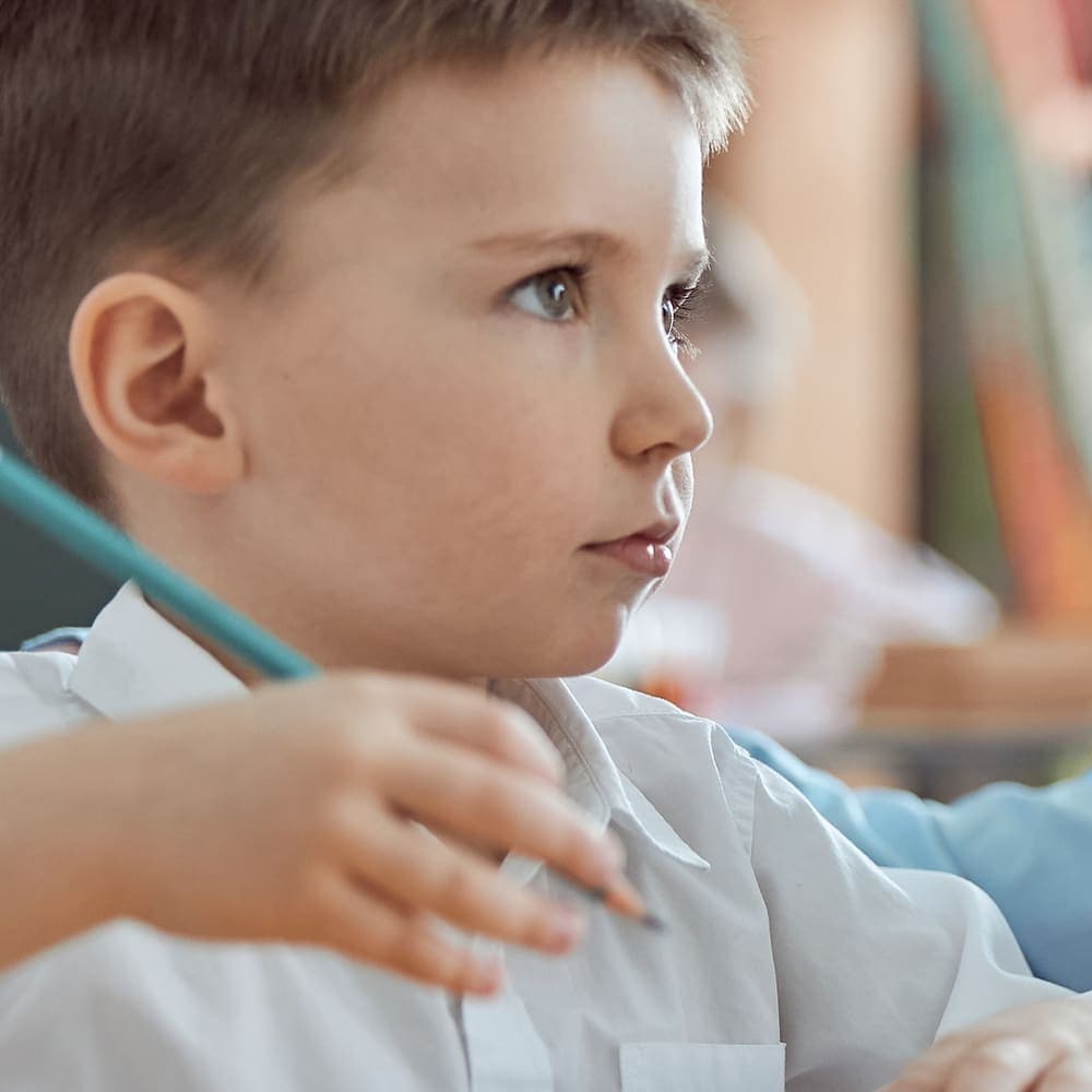 A young student listening thoughtfully in class