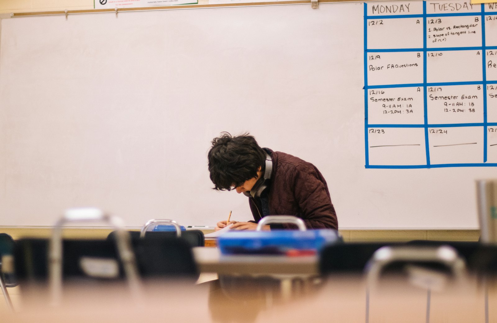 A student writing a reflection at their desk