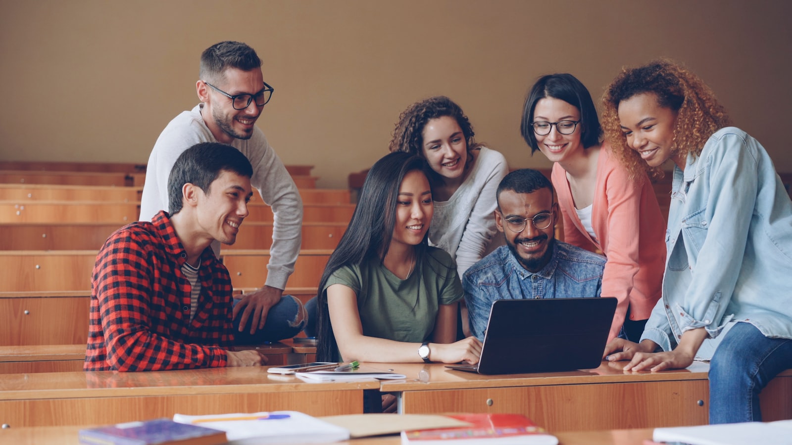 A group of students working together around a laptop
